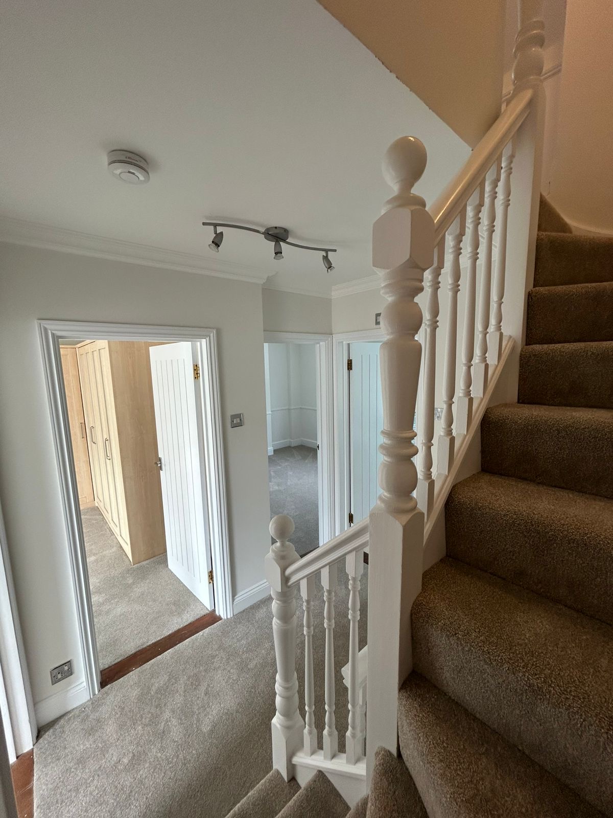 Upper landing with white banister, doors and freshly painted walls