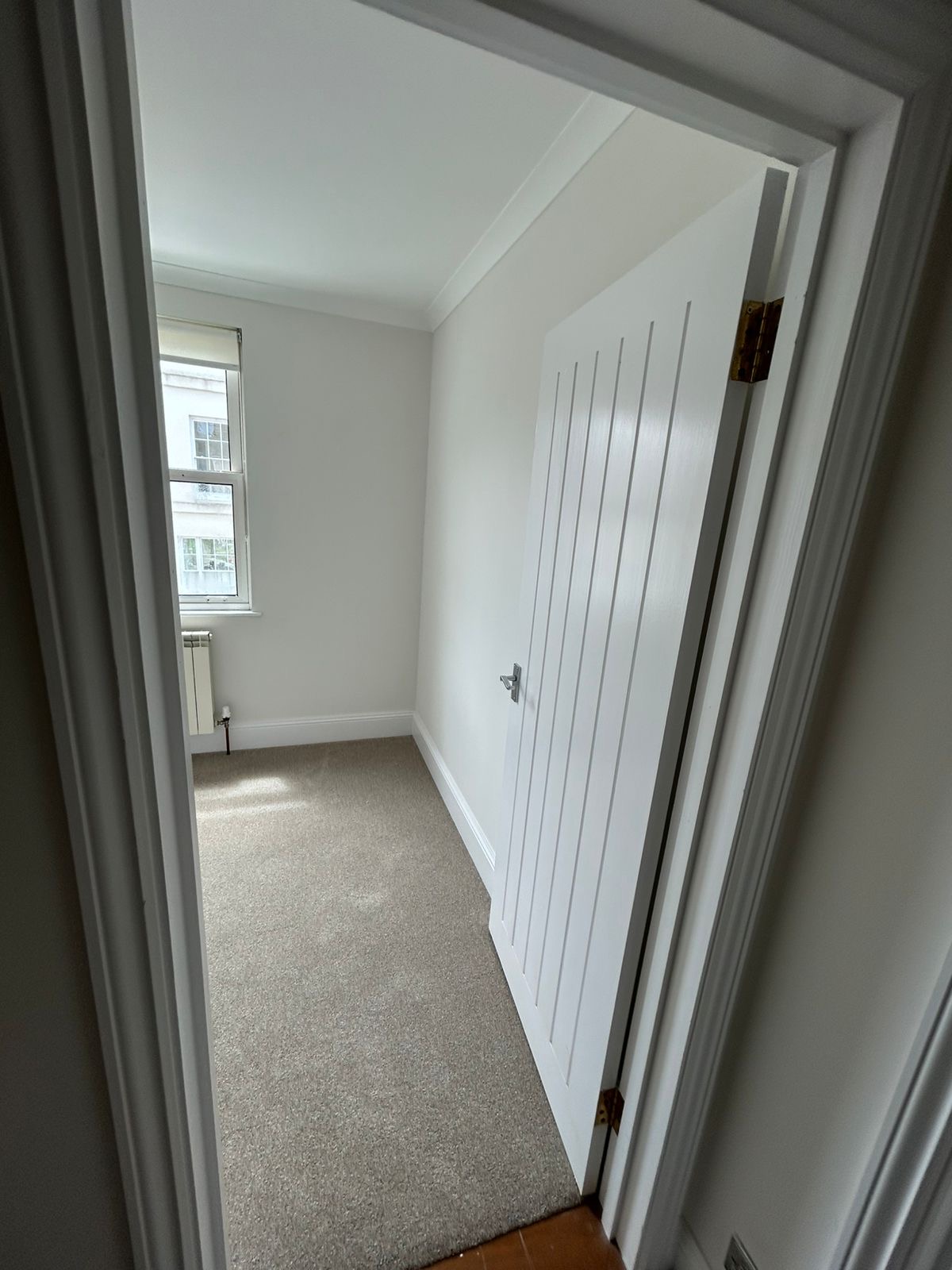 Landing doorway looking into a bedroom with freshly painted trim