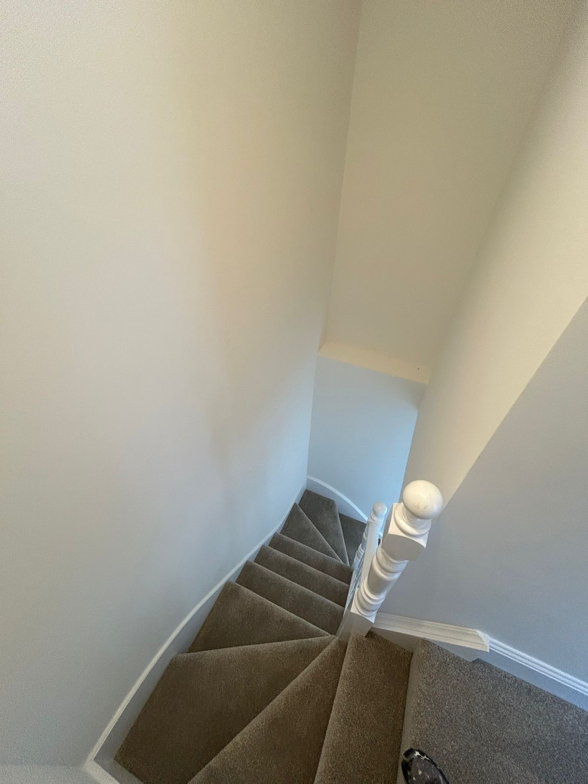 Staircase with fresh neutral walls, white spindles and skirting