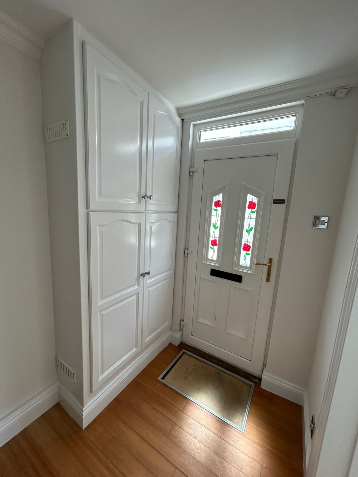 Entrance porch with built-in white cupboards and painted door reveal
