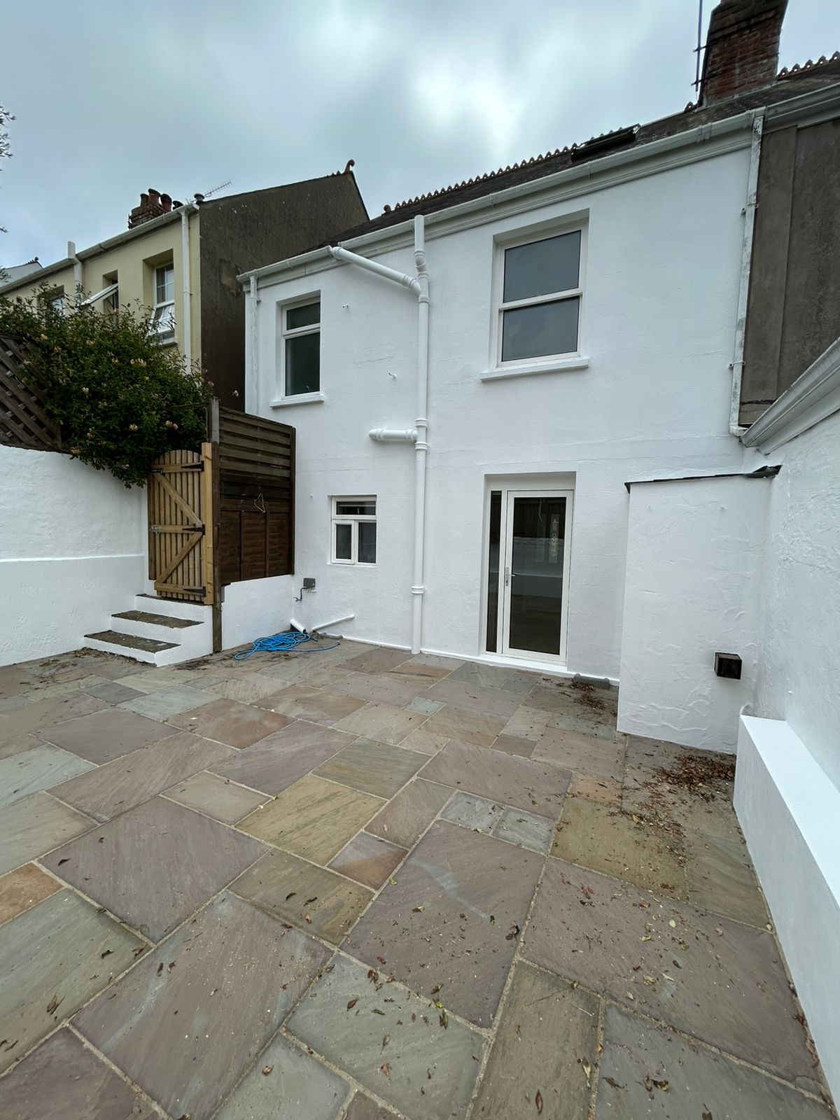 Rear of Guernsey property freshly painted in brilliant white with new patio