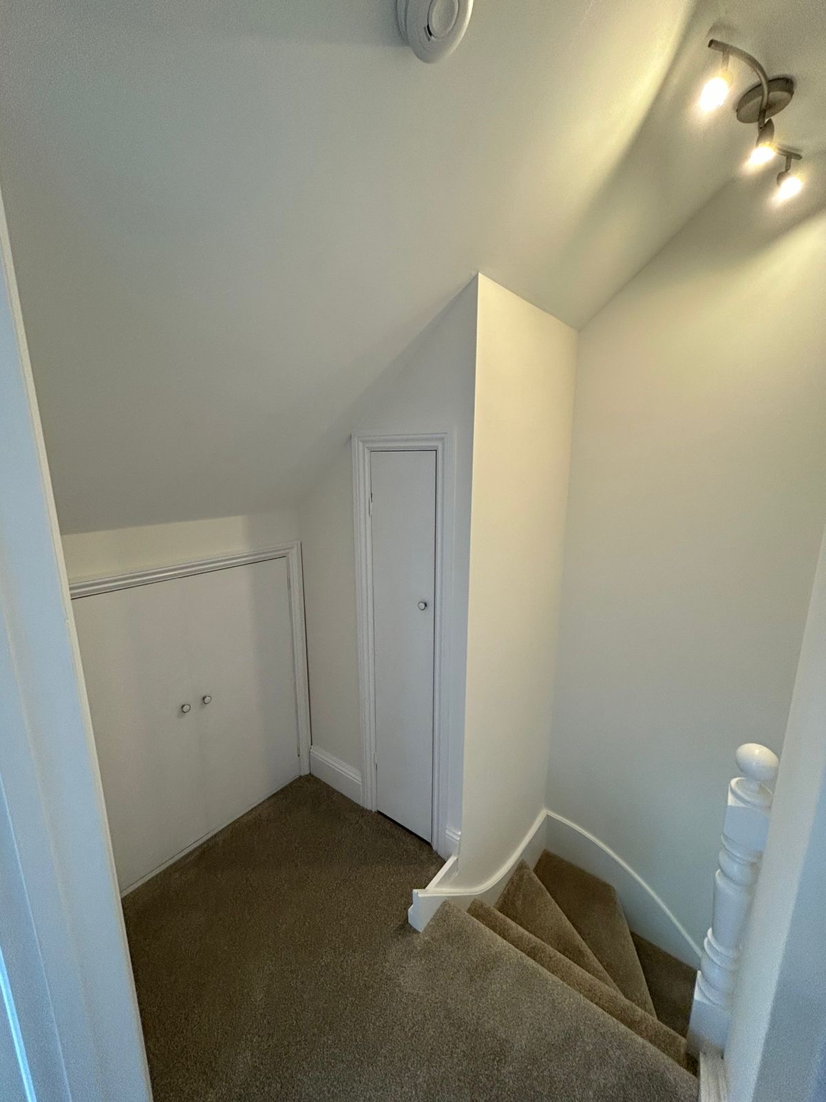 Upper landing with painted walls, storage doors and staircase