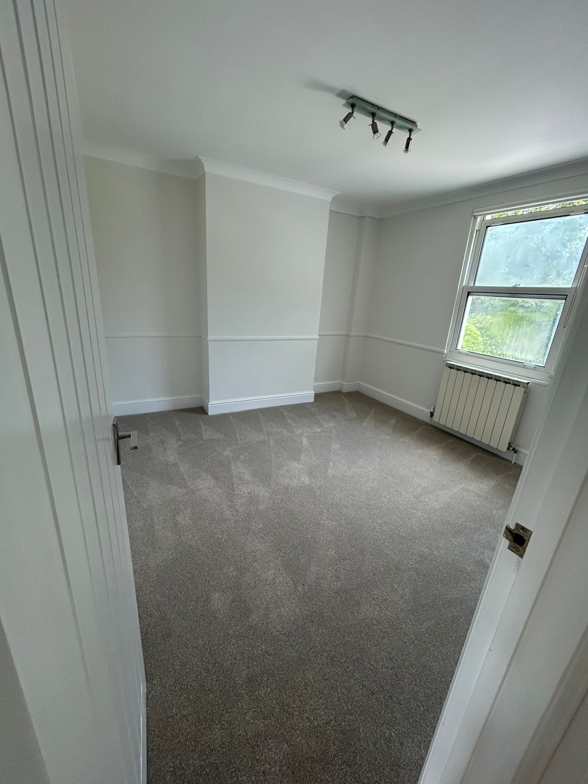 Children's bedroom with white walls, painted dado rail and window reveal
