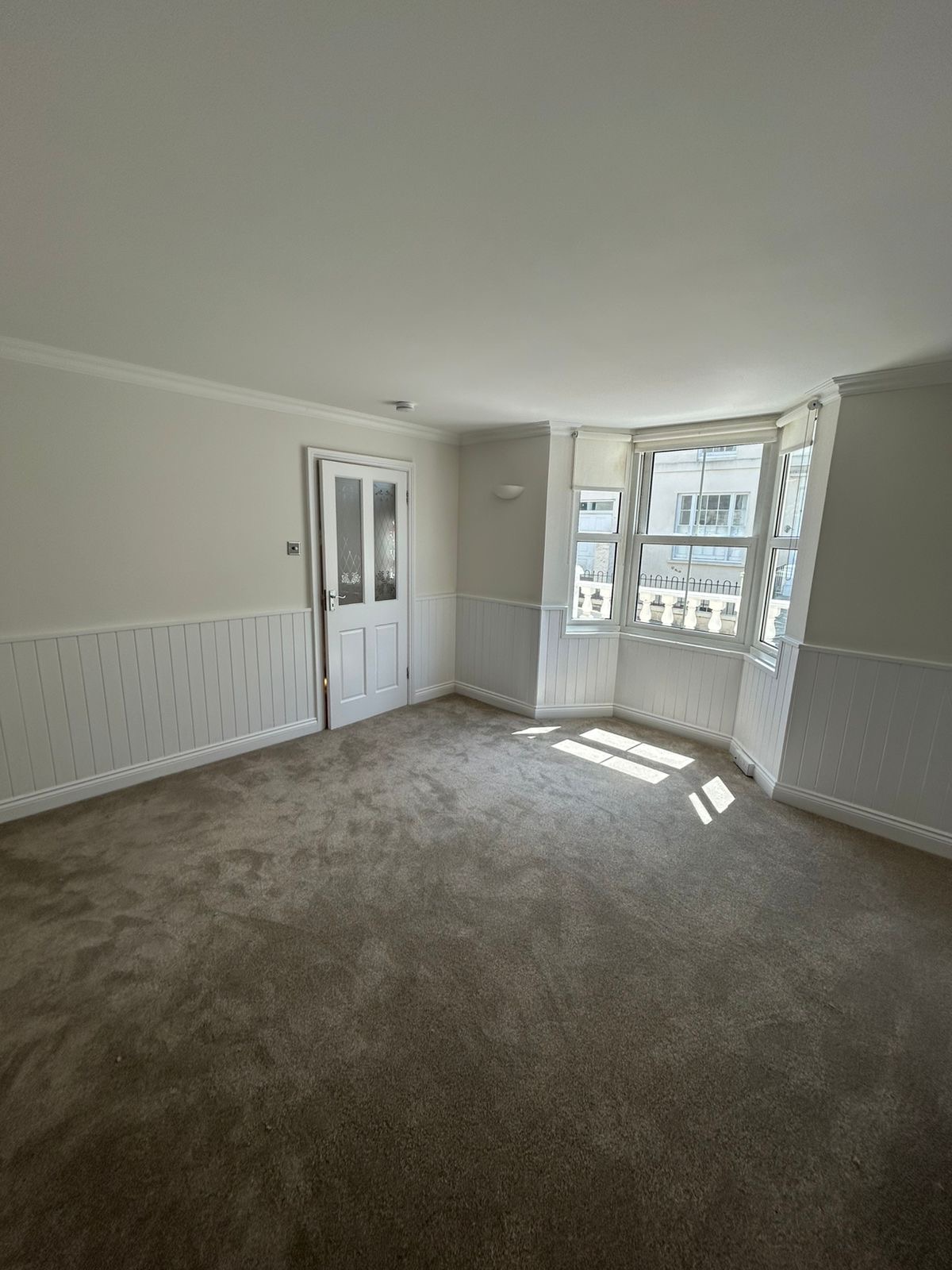 Bay-window sitting room with wainscot panelling and painted trim