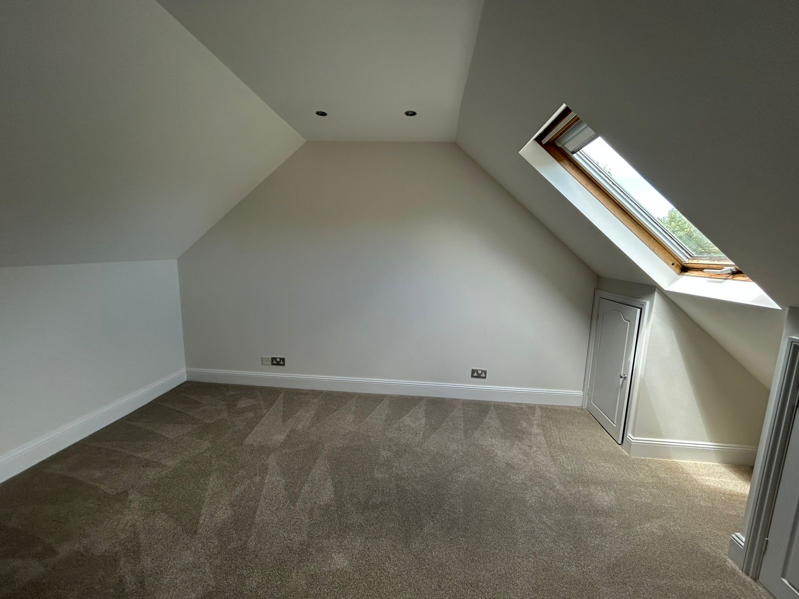 Second loft bedroom with sloped ceiling and skylight reveal