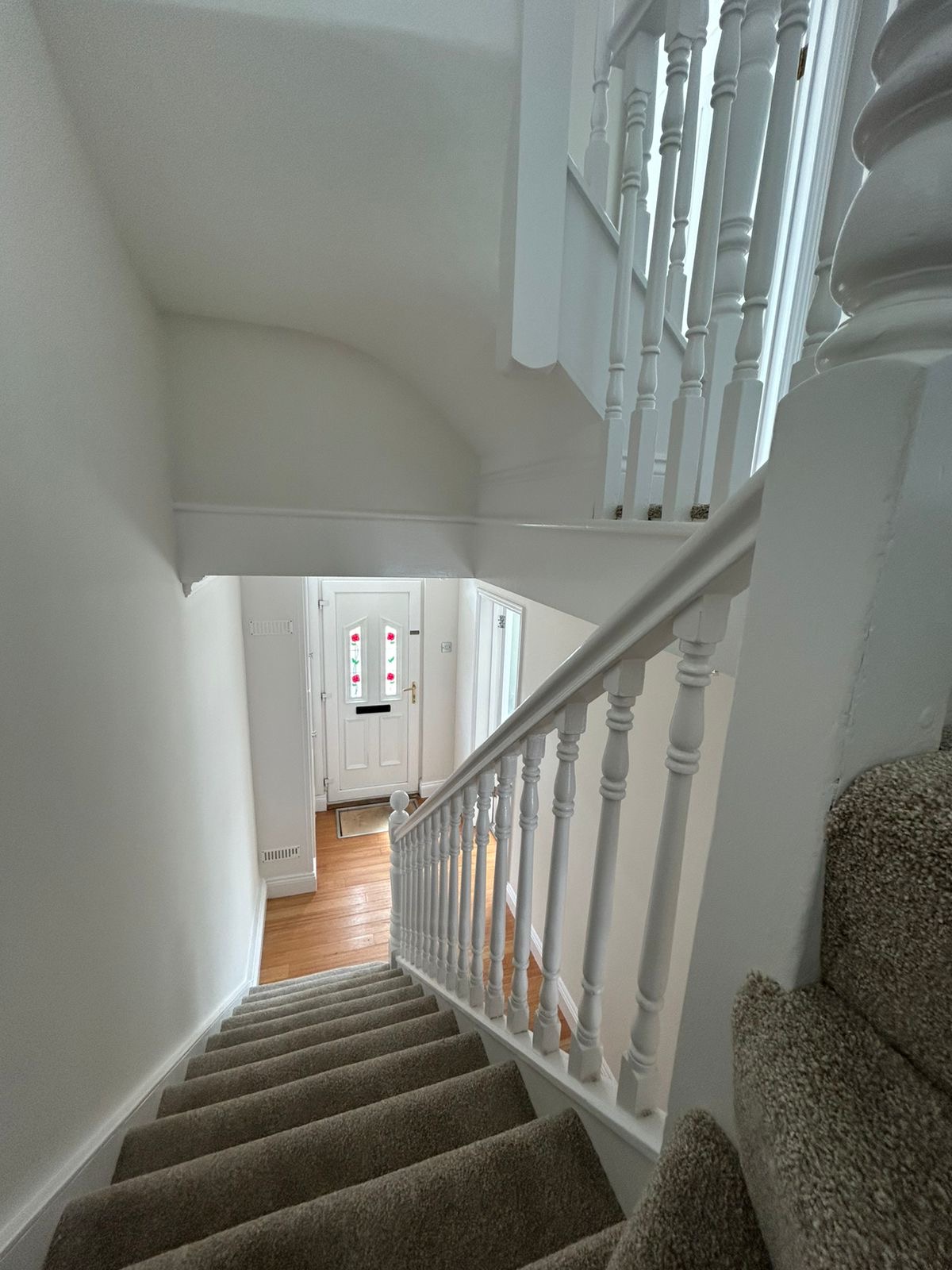 Main staircase and hallway with white banister and painted walls