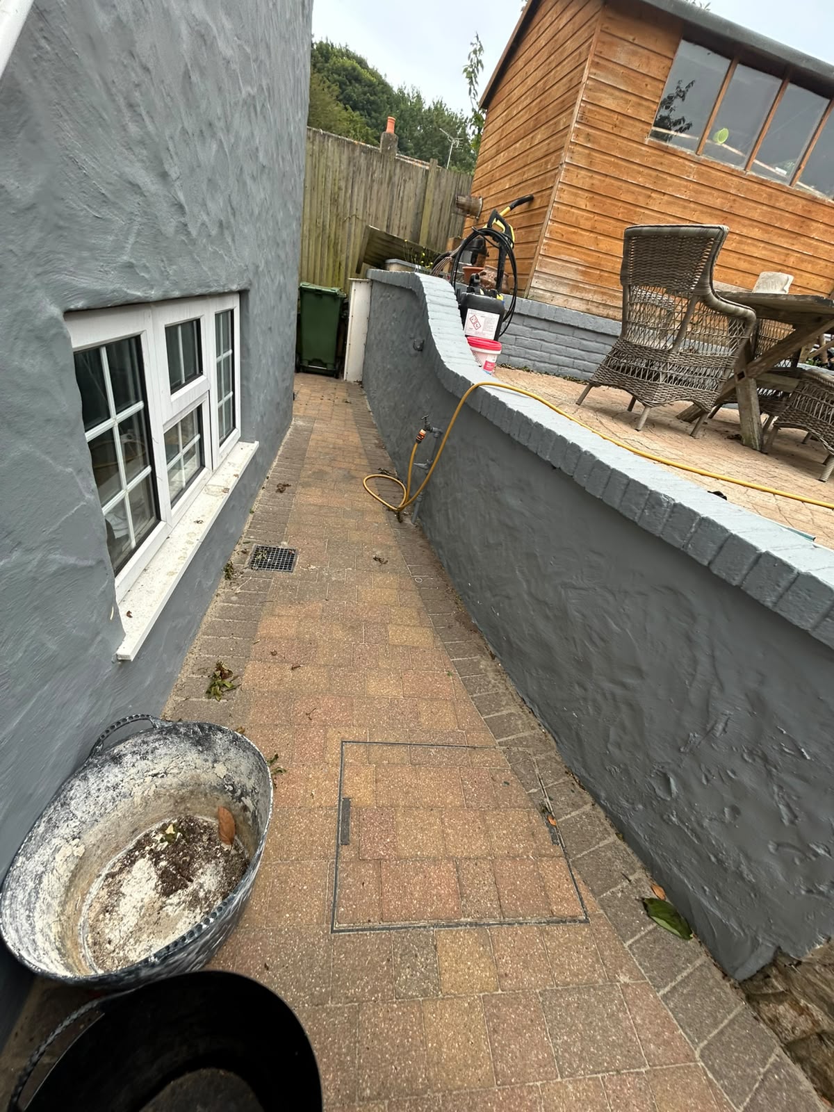 Side passage with slate grey render and white sliding sash windows