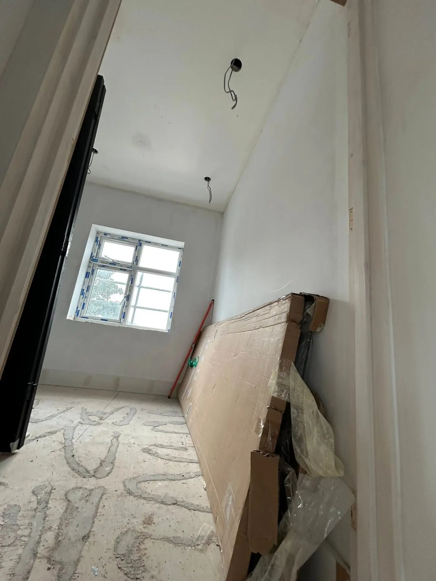 Doorway before — unfinished plasterboard and bare door