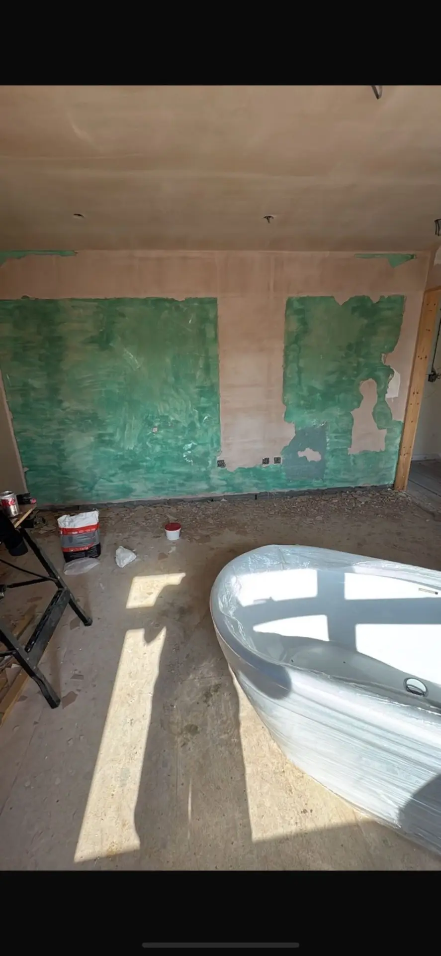 Storage area before — unfinished plasterboard and shelving