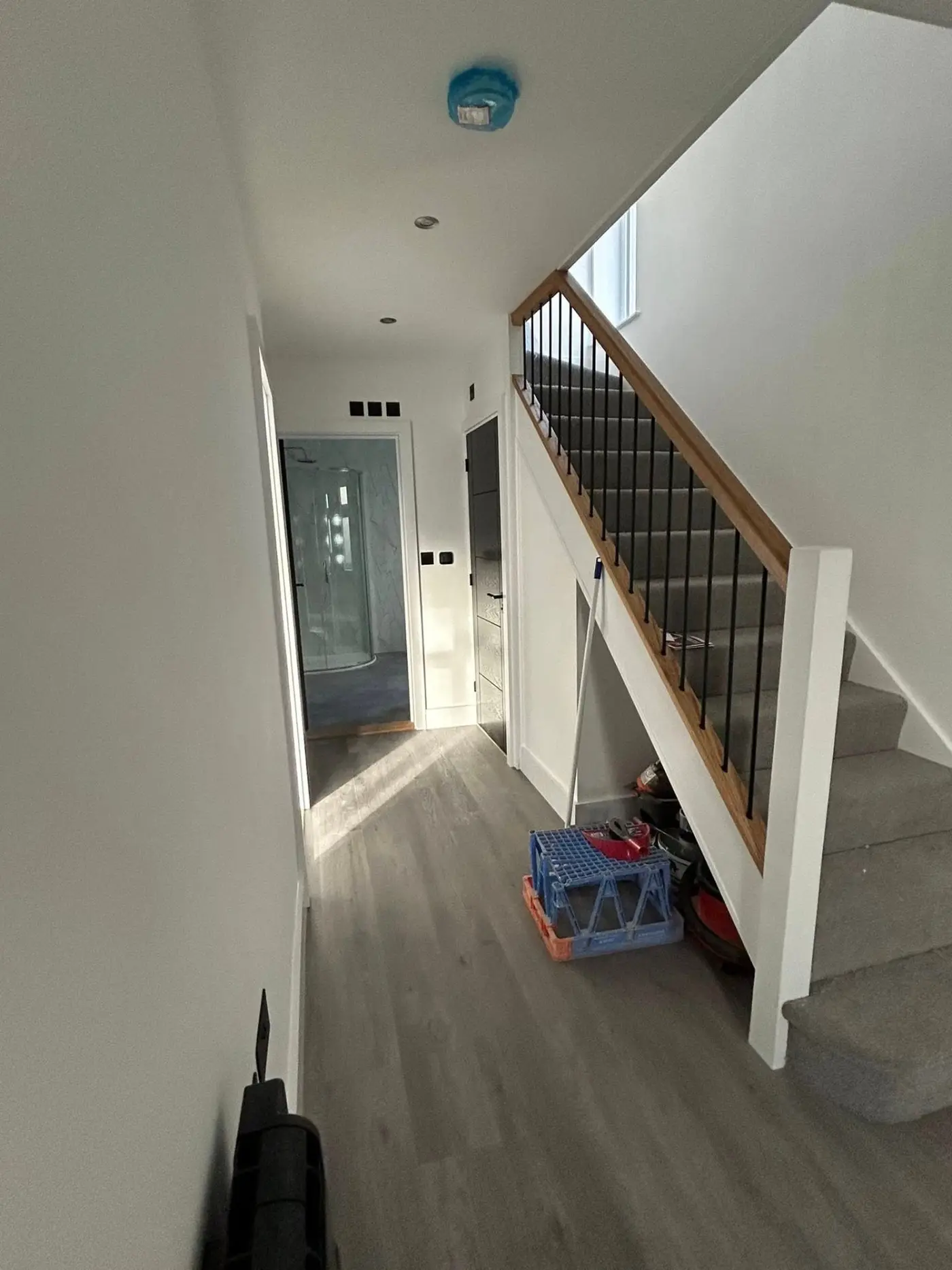 Hallway with staircase, painted walls and shower room beyond