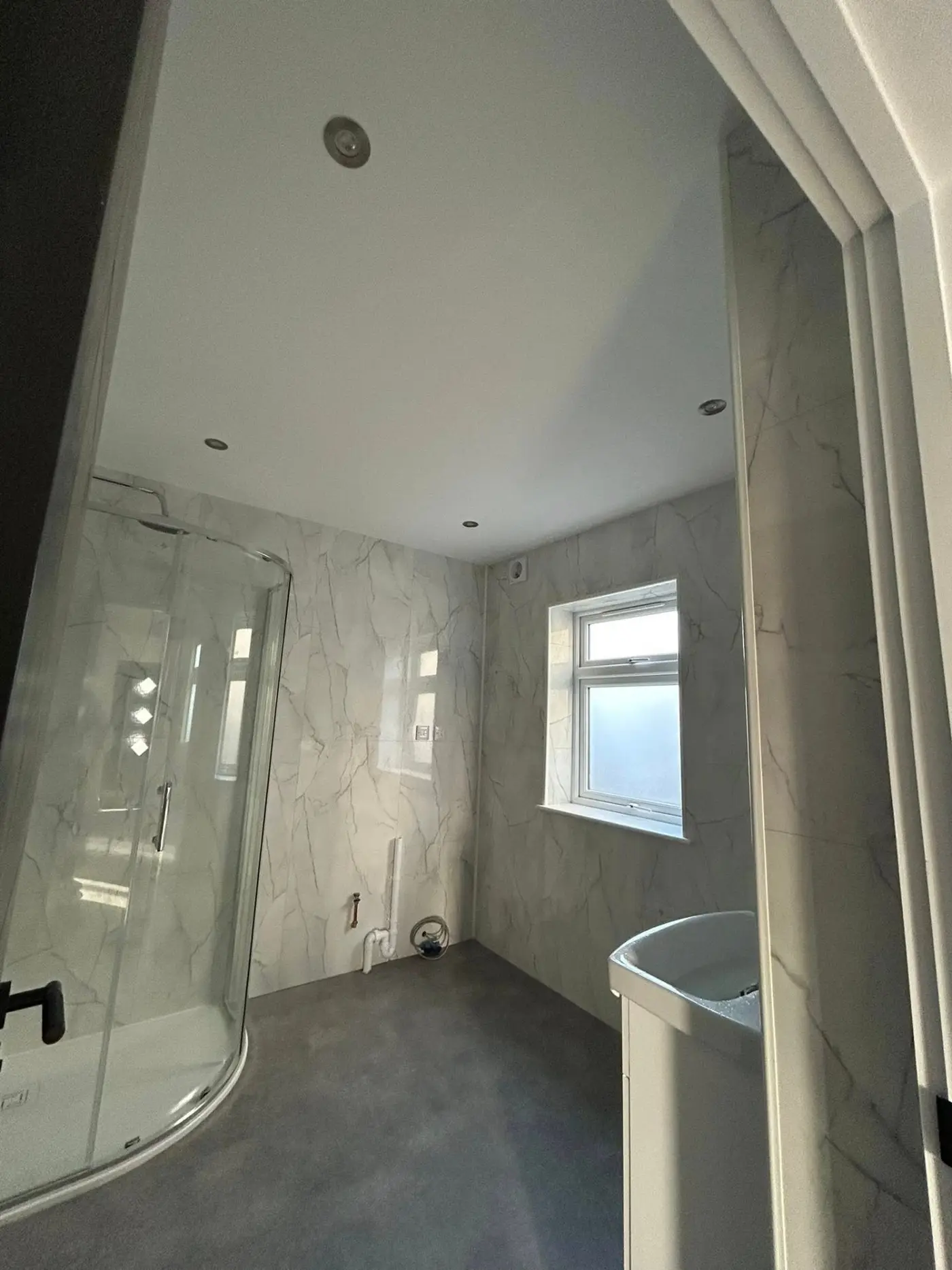 En-suite shower room with marble-effect tiles and painted ceiling