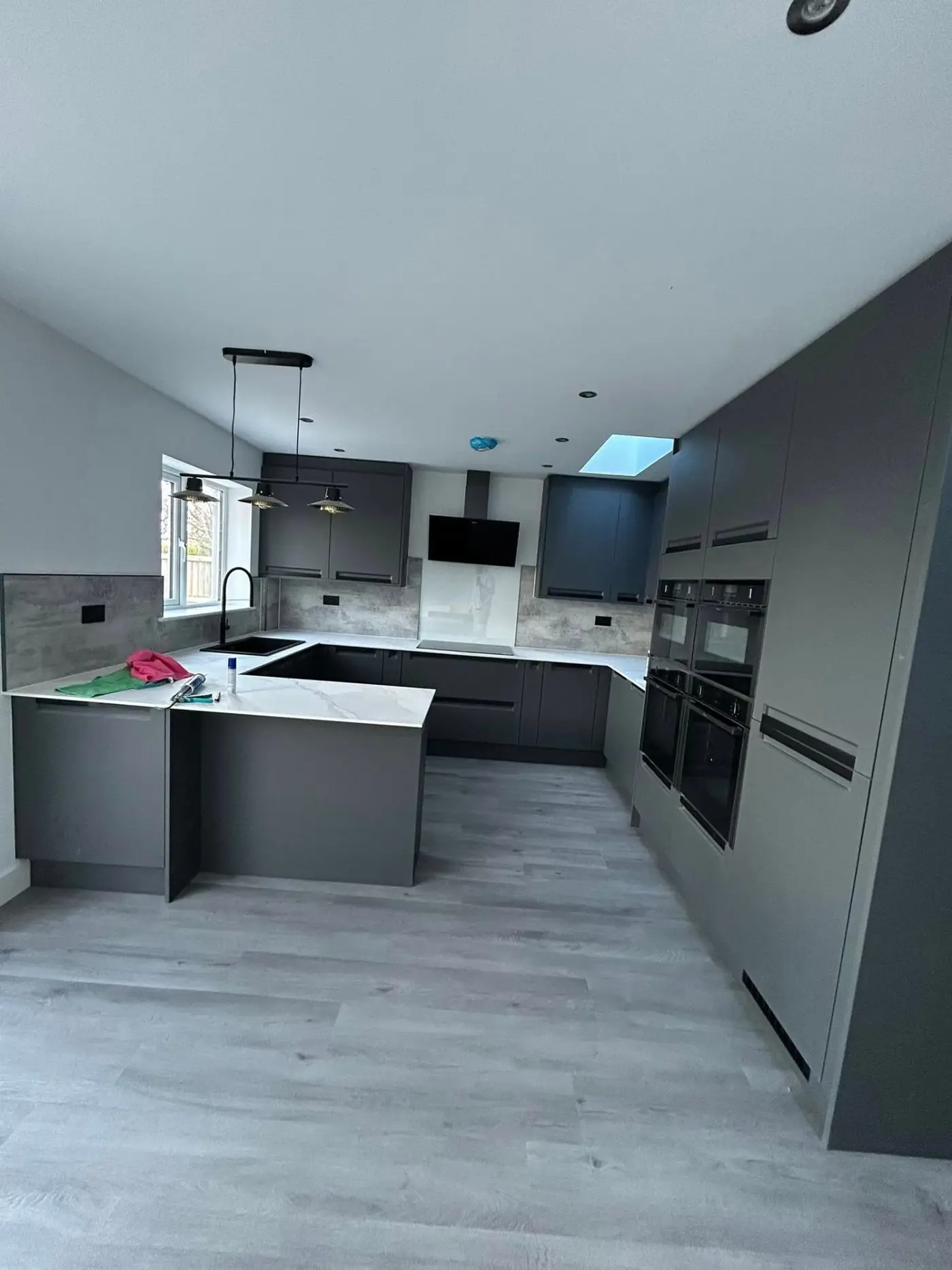 Modern grey kitchen with marble worktops, skylight and pendant lights
