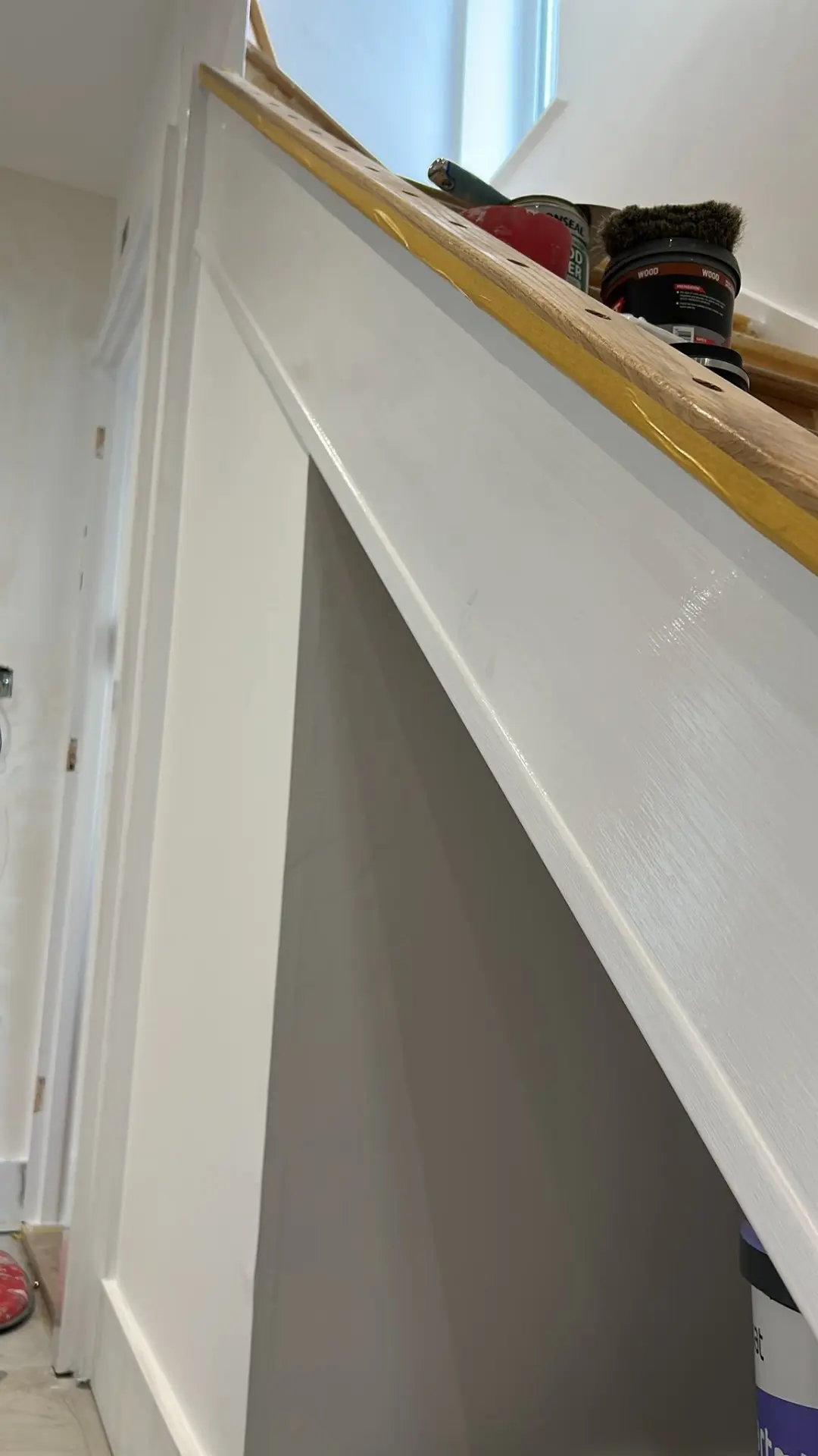 Staircase woodwork with freshly painted stringer and handrail