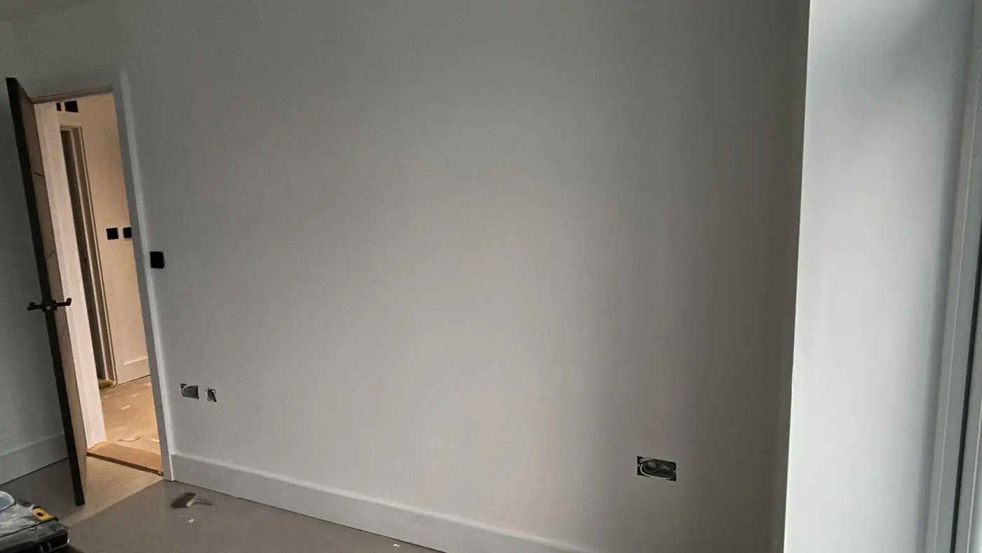 Room with smooth grey walls and doorway through to hallway