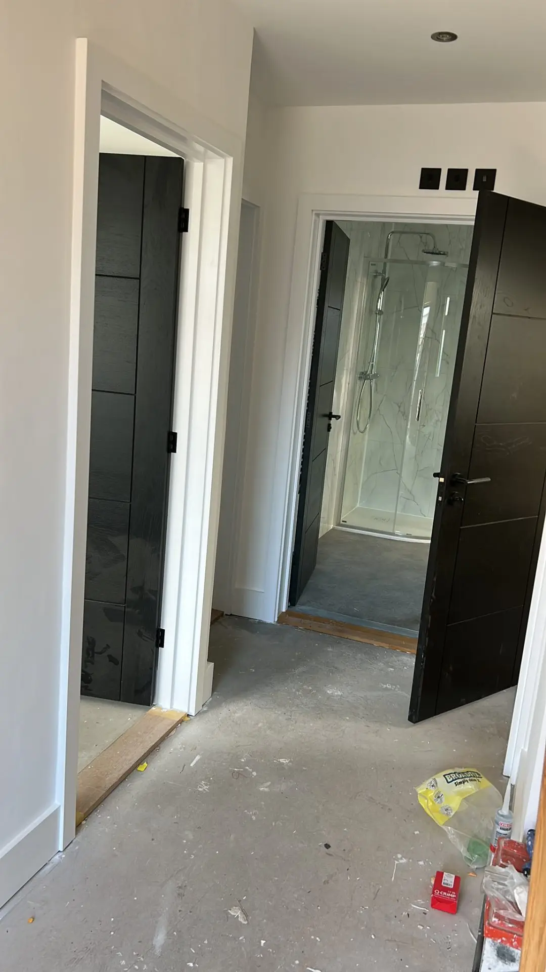 Hallway with black doors, white painted walls and en-suite shower room