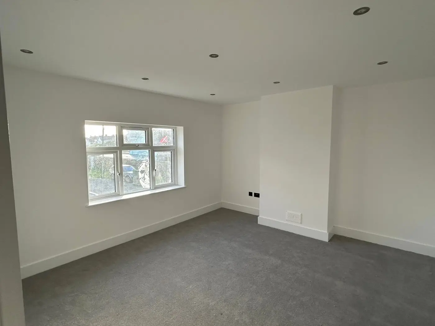 Finished bedroom with large window and clean white walls