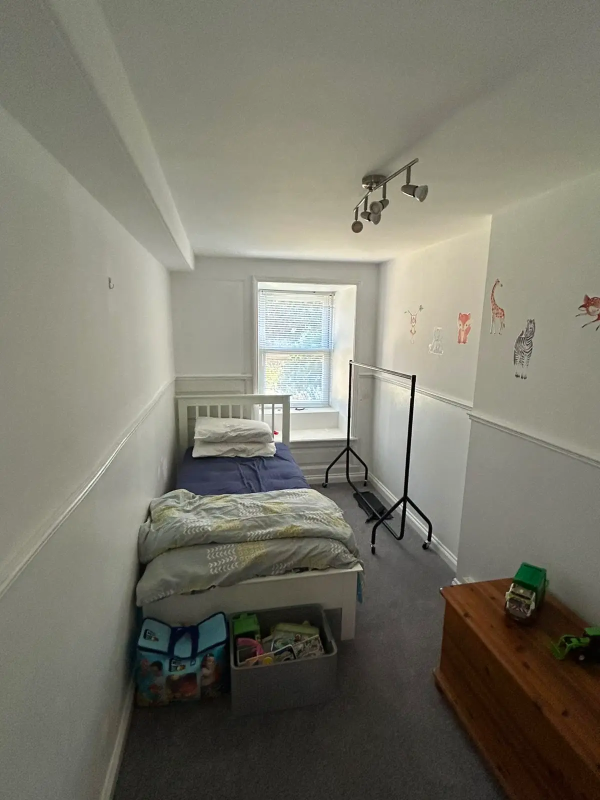 Child's bedroom with crisp white walls, animal decals and painted dado rail