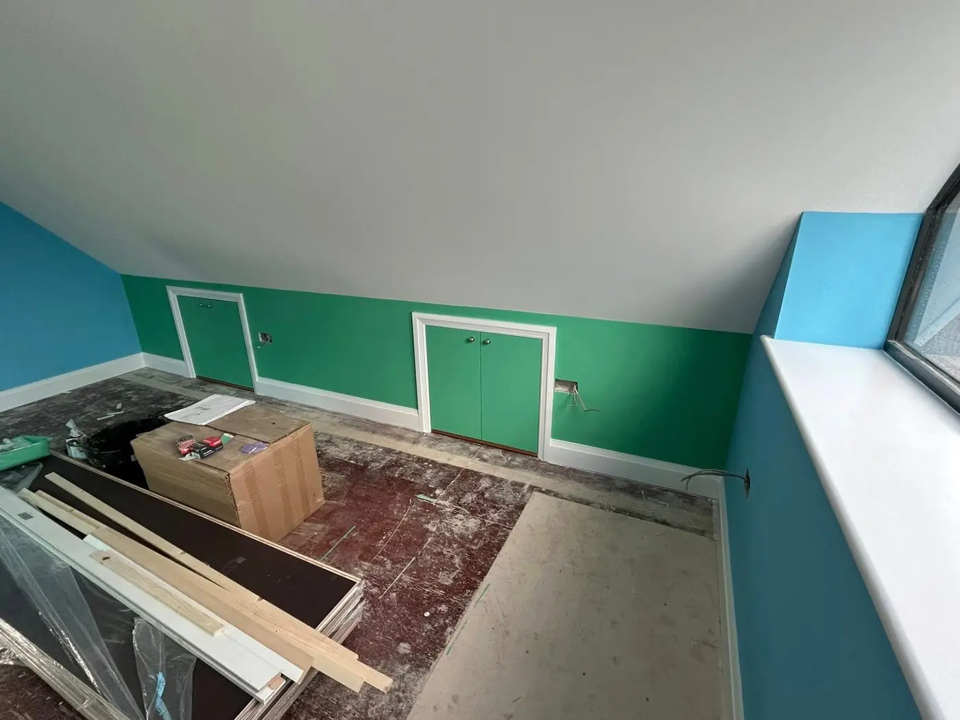 Green feature wall with white storage cupboard doors