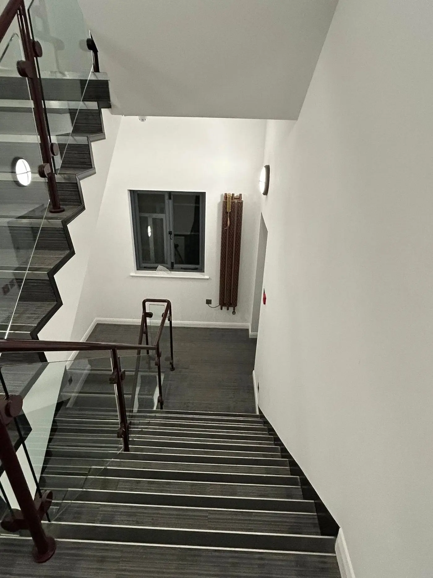 Staircase with glass balustrade and painted walls