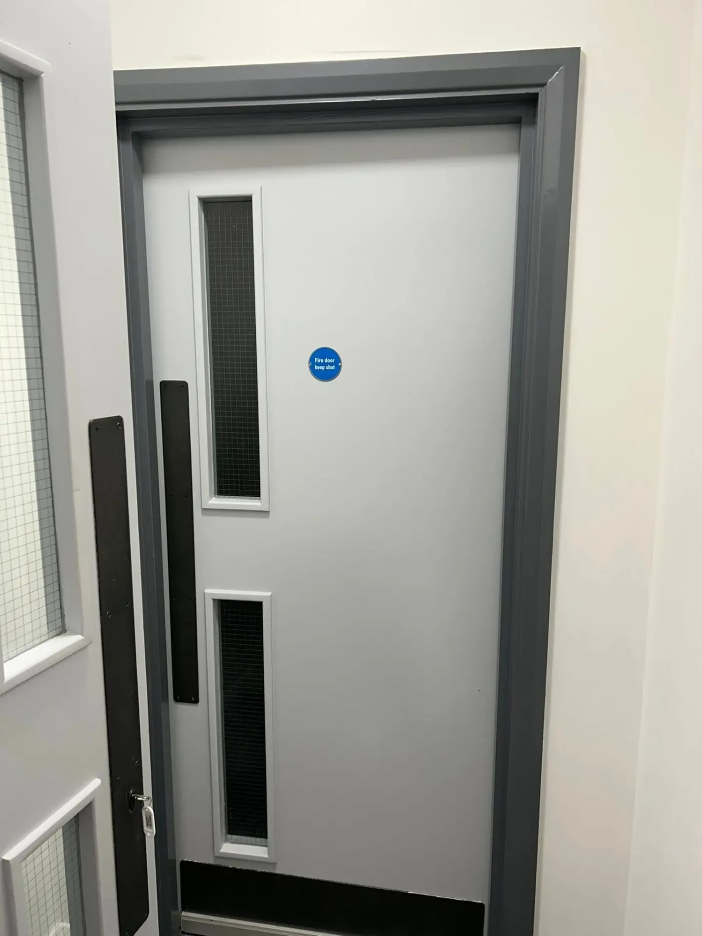 Fire door with grey frame, freshly painted