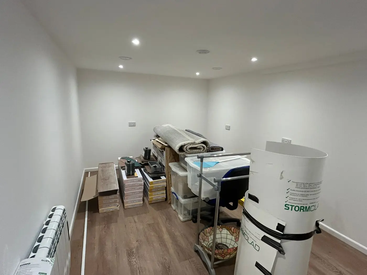 Storage room with fresh white walls and wooden flooring
