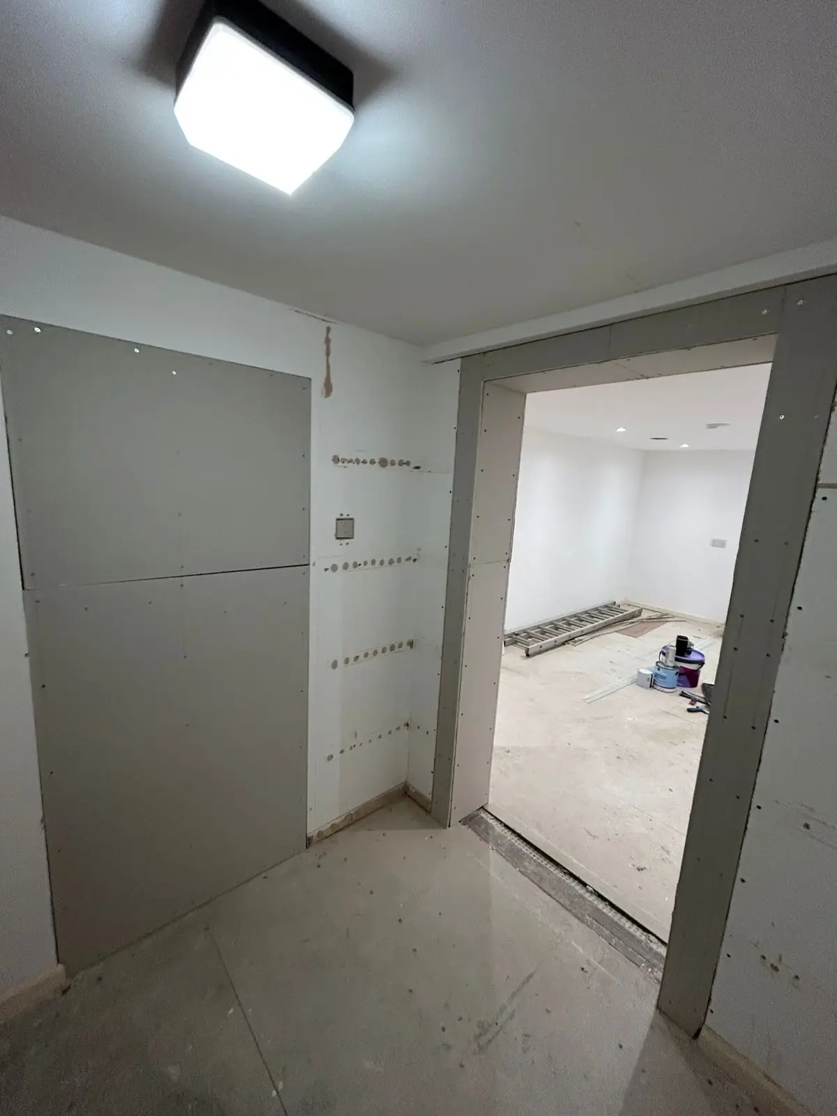 Hallway before — bare plasterboard doorway and light