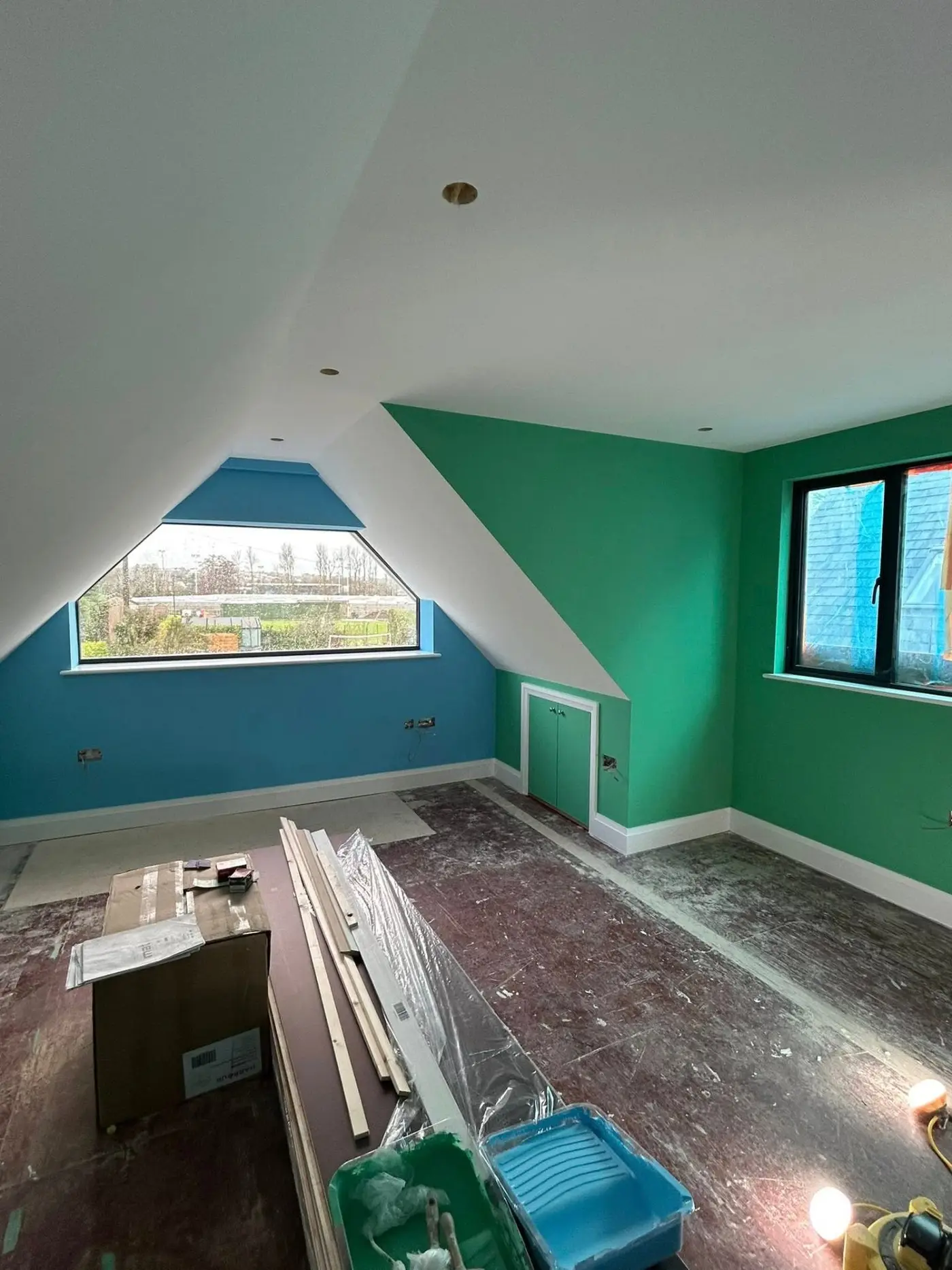 Loft conversion with bold green and blue feature walls