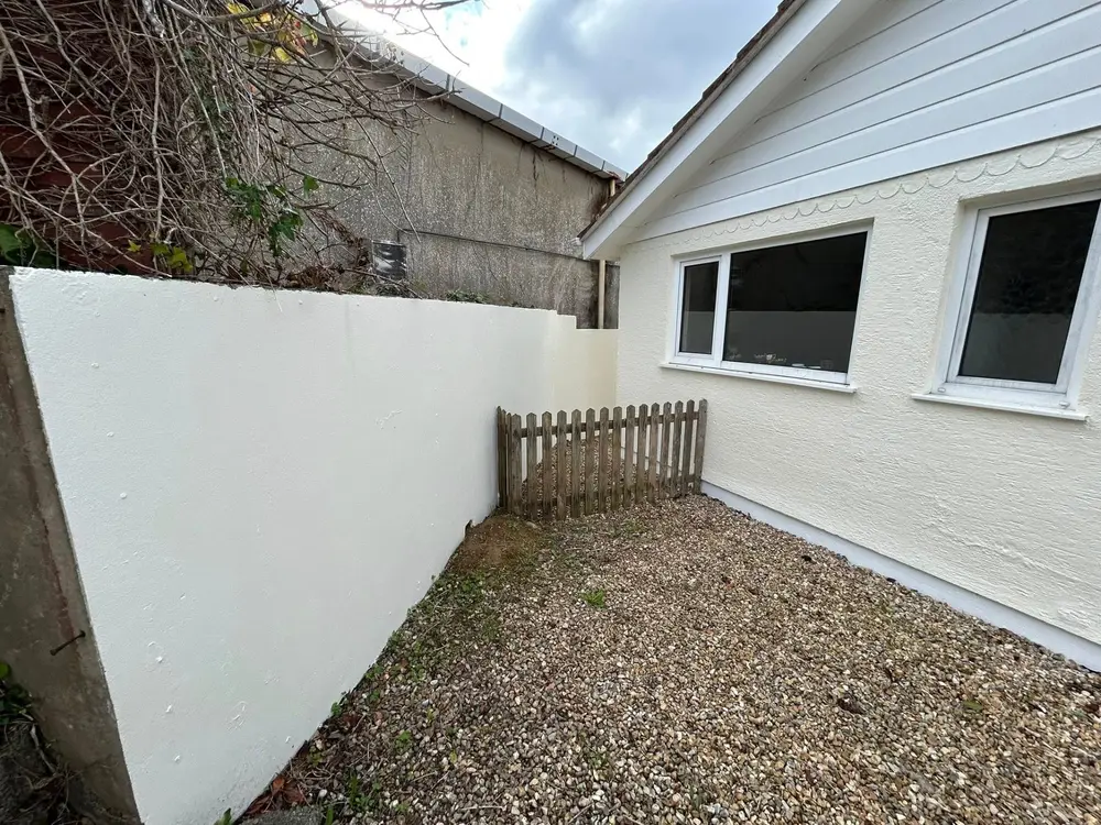 Freshly repainted white masonry exterior wall on a Guernsey property